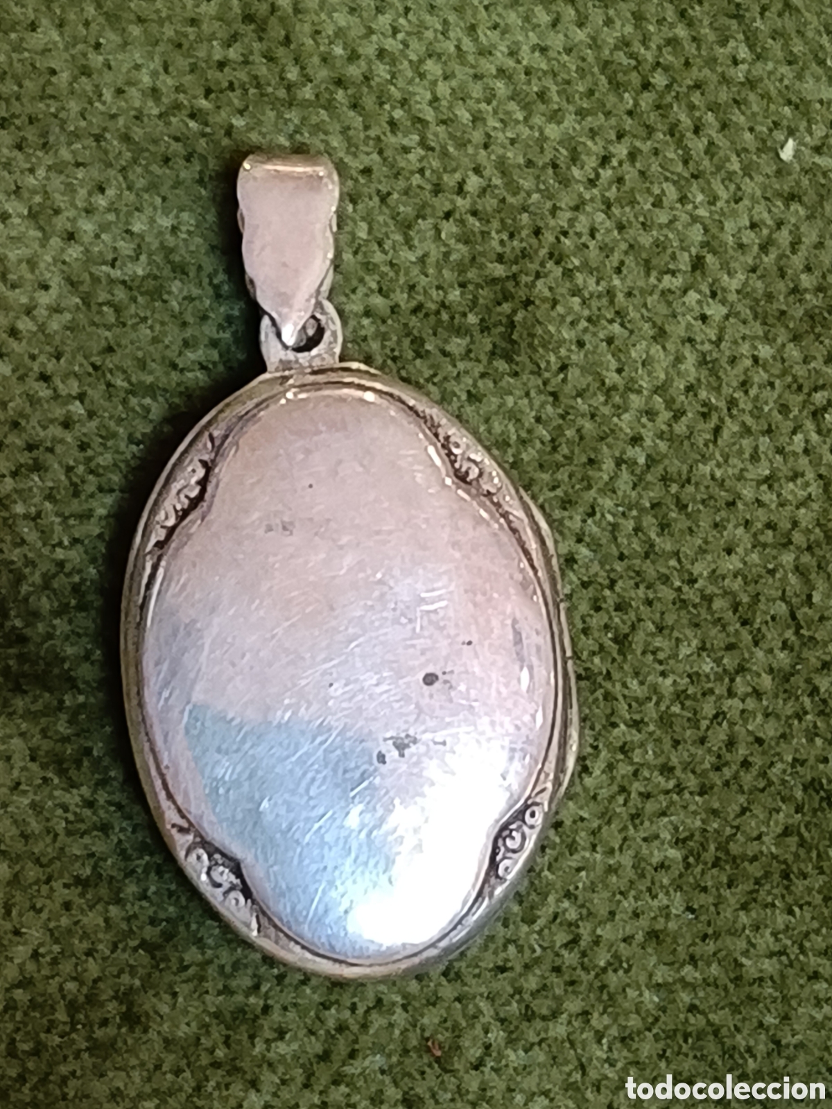 Joyeria: Colgante portafotos, tambi&eacute;n conocido como guardapelo, tiene una forma ovalada y est&aacute; hecho de plata