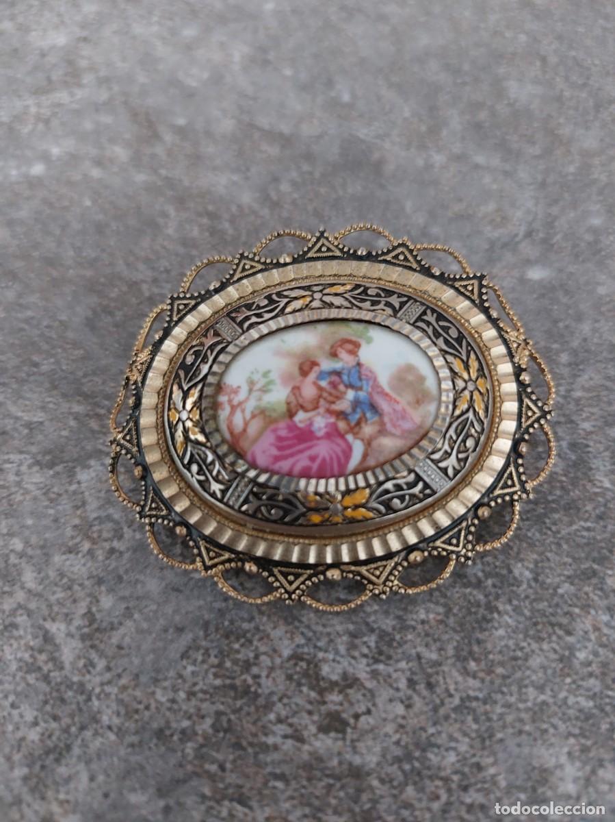 Joyeria: Broche vintage estilo Damascene con un inserto ovalado que representa una escena rom&aacute;ntica.