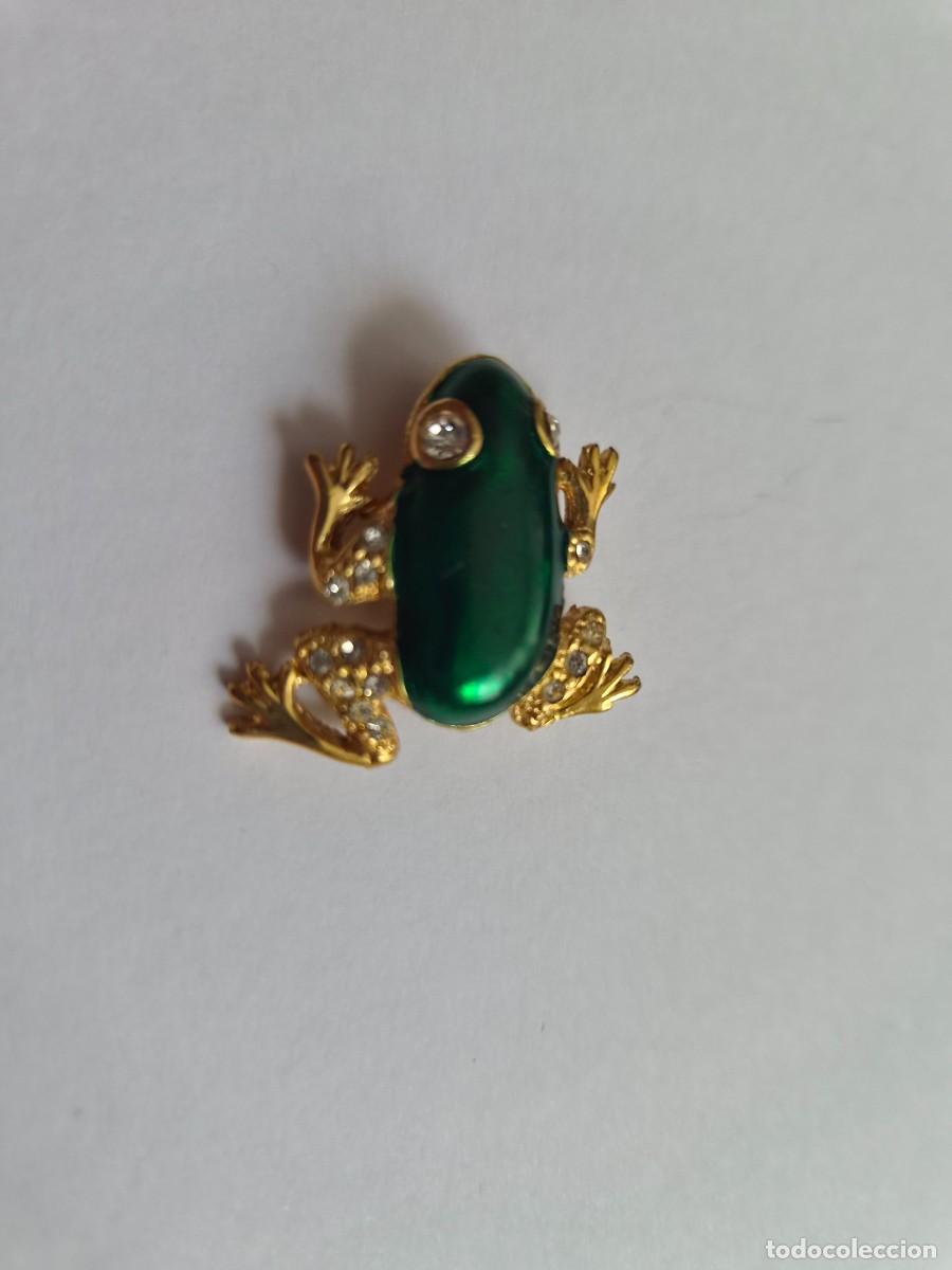 Joyeria: Broche de rana en tono dorado con esmalte e incrustaciones de cristal blanco.