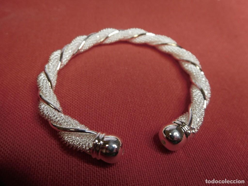 Joyeria: Brazalete r&iacute;gido de tipo esclava torcida (twisted bangle), caracterizado por su llamativo contraste