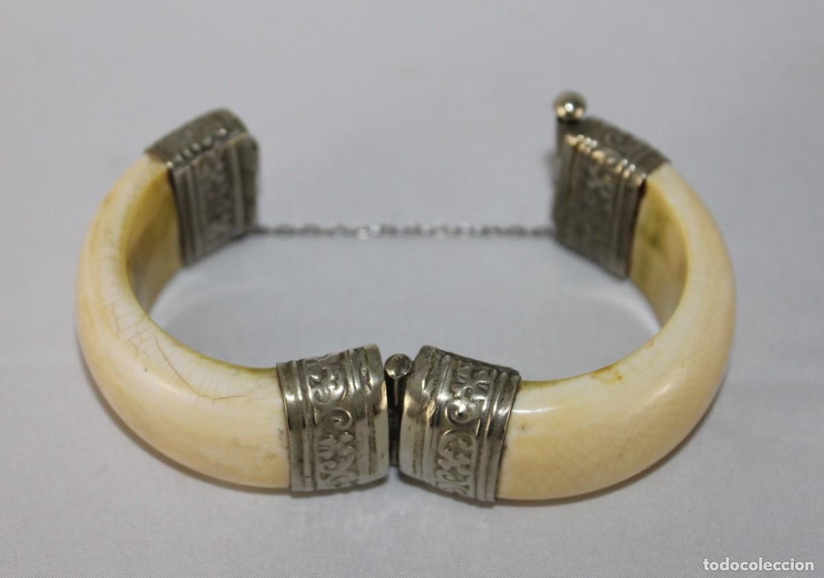 Joyeria: Pulsera o brazalete de hueso y metal plateado decorado.