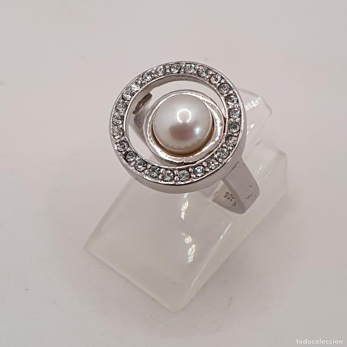 Joyeria: Elegante sortija de corte cl&aacute;sico en plata de ley, circonitas talla brillante y perla natural.