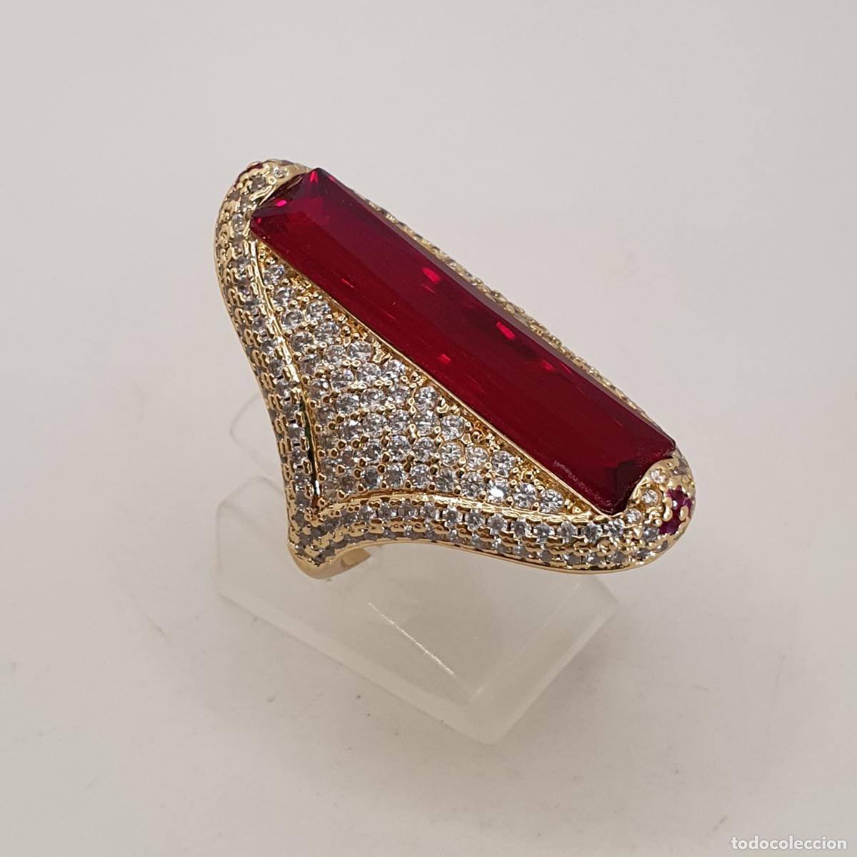 Joyeria: Extremado anillo de lujo, acabados en oro, cuajado de circonitas y gran rub&iacute; creado talla baguette.