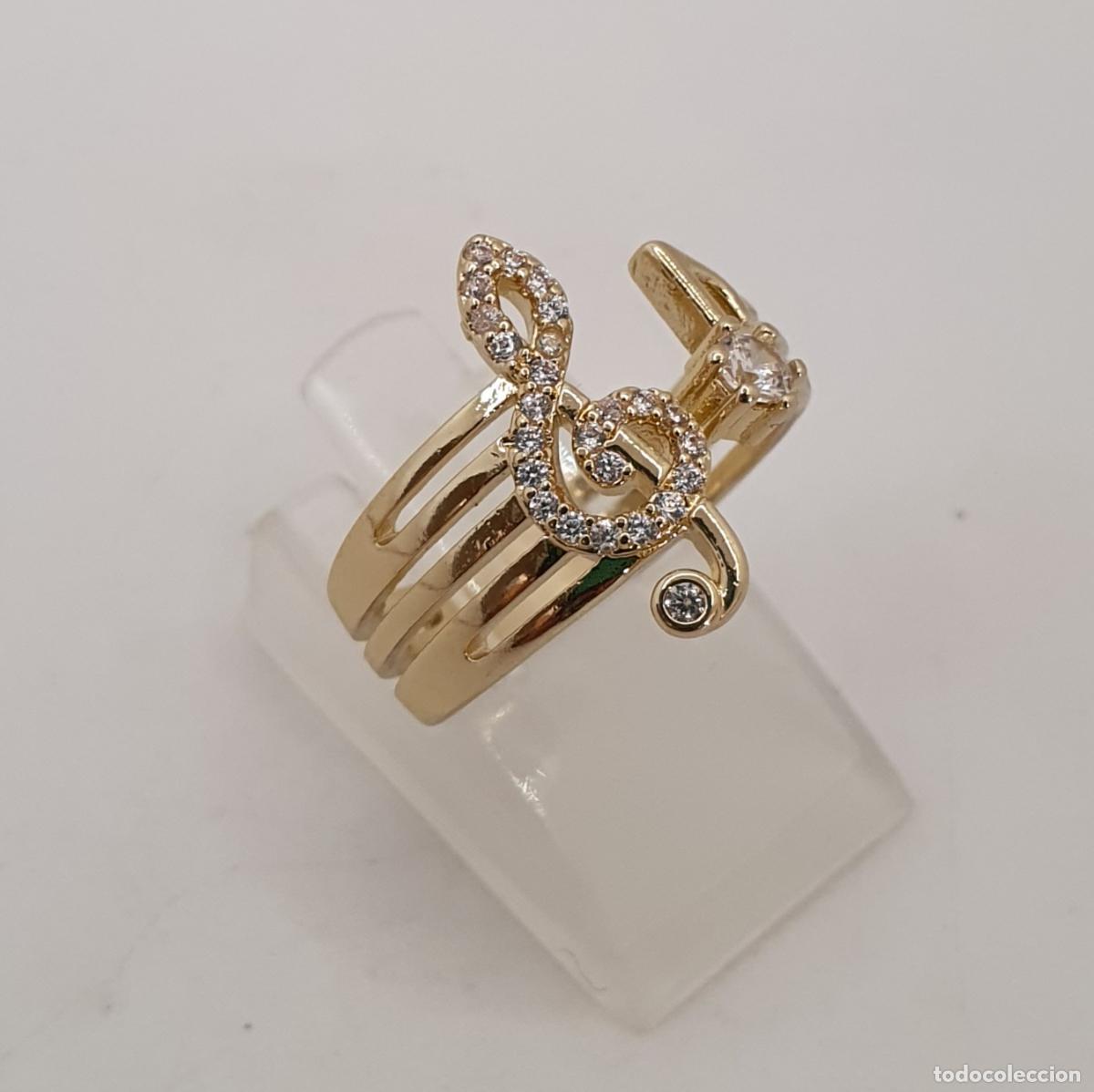 Joaillerie: Bella sortija de clave de sol y nota musical con acabados en oro y circonitas talla brillante.