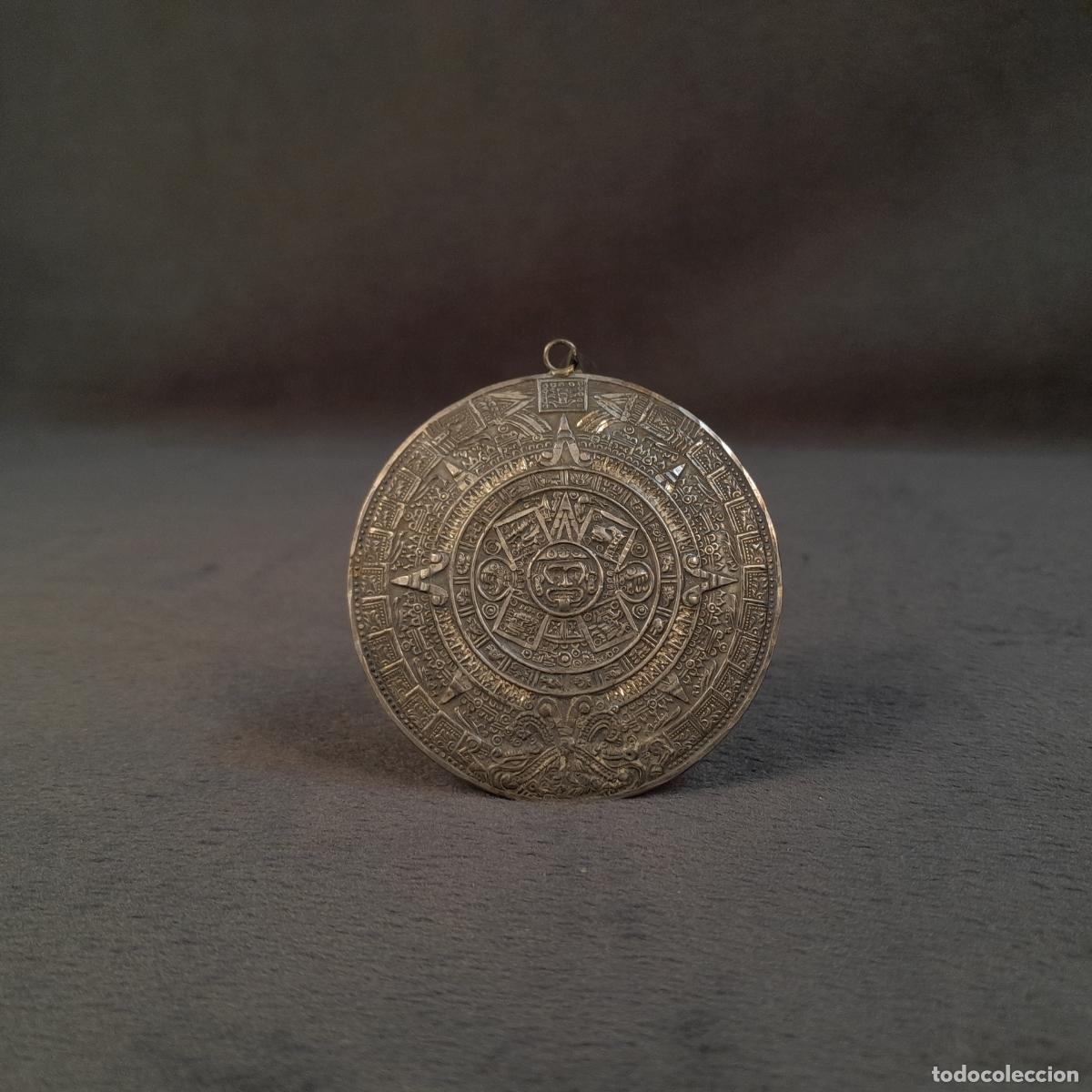 Joyeria: J-4617. COLGANTE EN PLATA CON REPRESENTACI&Oacute;N DE LA PIEDRA DEL SOL O CALENDARIO AZTECA. SIGLO XX.