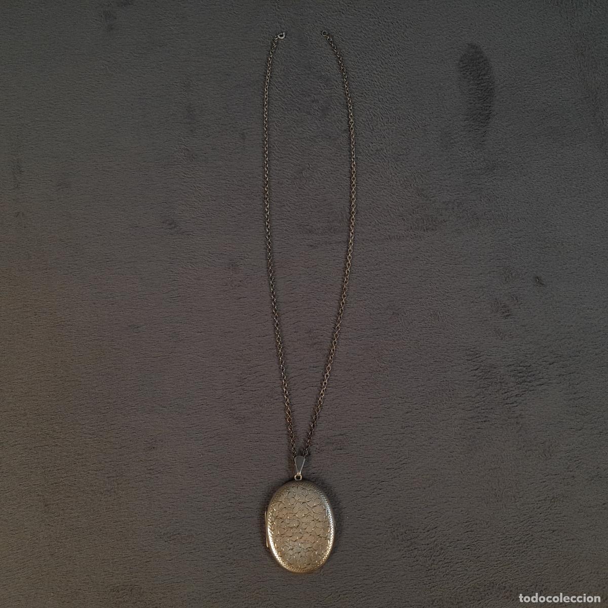 Joyeria: J-4620. COLGANTE GUARDAFOTOS OVALADO EN PLATA CON CADENA Y MOTIVOS FLORALES GUILOCHEADOS. SIGLO XX.