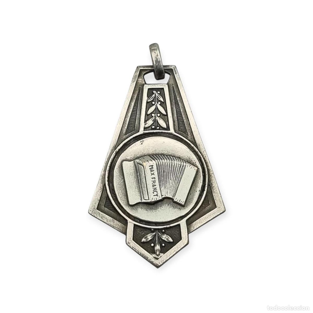 Joyeria: Medalla francesa vintage Max Francy con acorde&oacute;n, metal plateado, art d&eacute;co tard&iacute;o, ca. 1930&ndash;1950