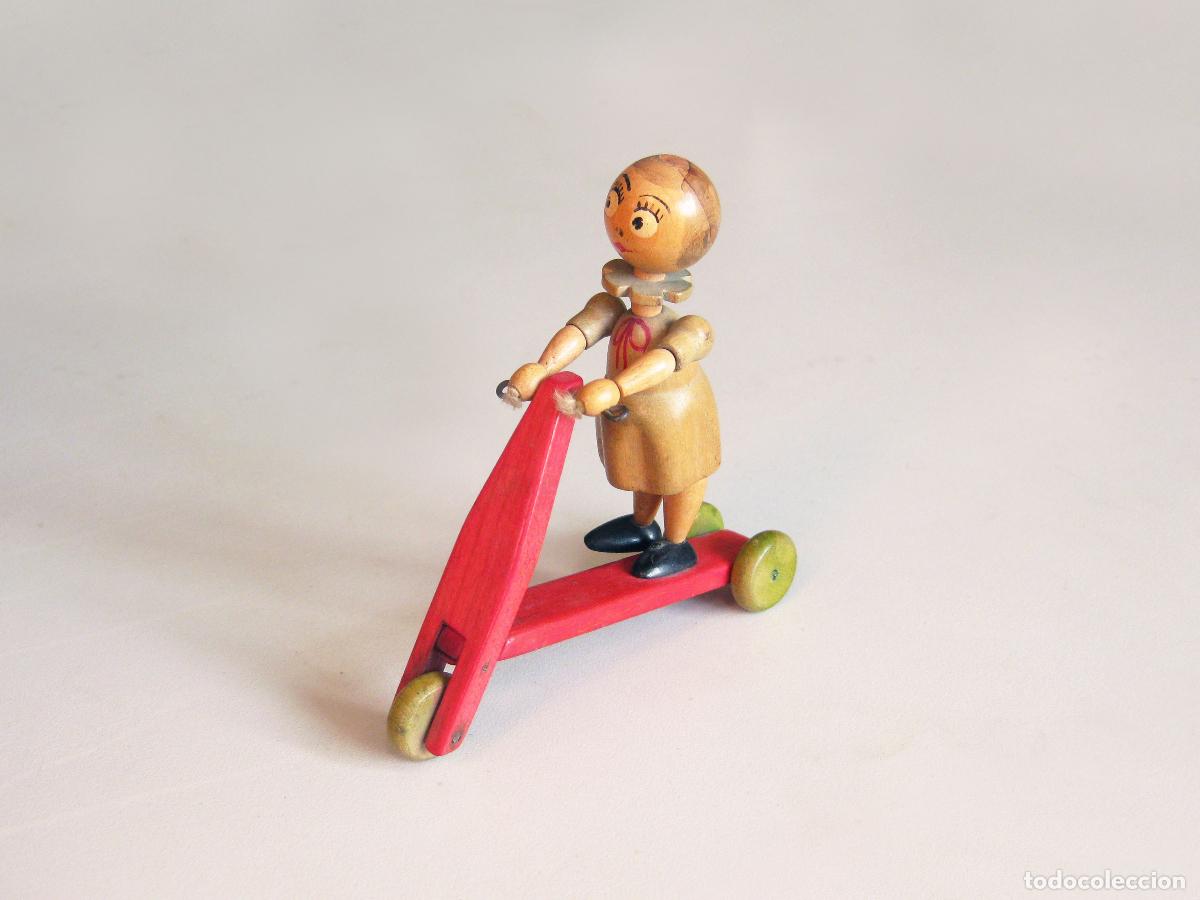 Juguetes antiguos y juegos de colecci&oacute;n: ANTIGUA FIGURA DE UNA NI&Ntilde;A MONTANDO EN PATINETE. MADERA TIPO GOULA.