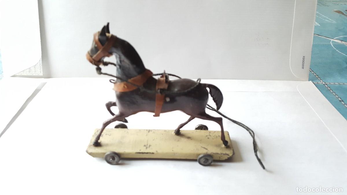 Juguetes antiguos: Caballo de hojalata con arreos sobre plataforma con ruedas de Juguetes Moreno (Madrid, 1900)