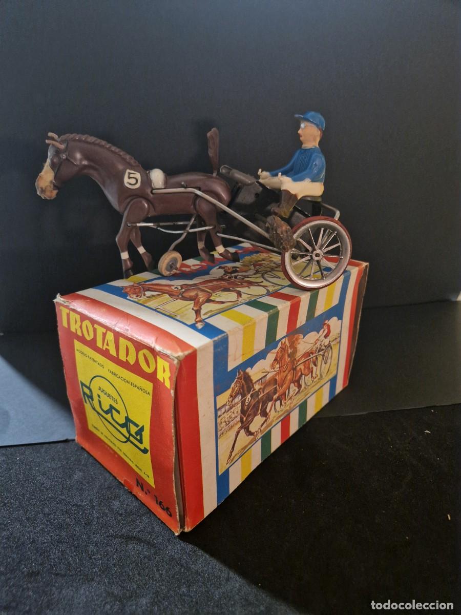 Juguetes antiguos de hojalata: Trotadora de rico. En su caja original.
