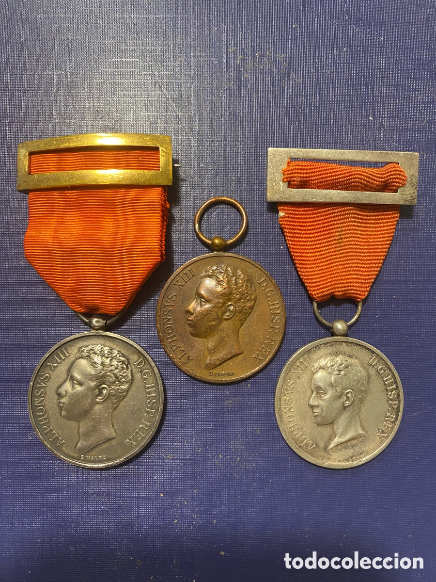 Medallas condecorativas: Tres medallas conmemorativas de la mayor&iacute;a de edad y jura del rey Alfonso Xlll.