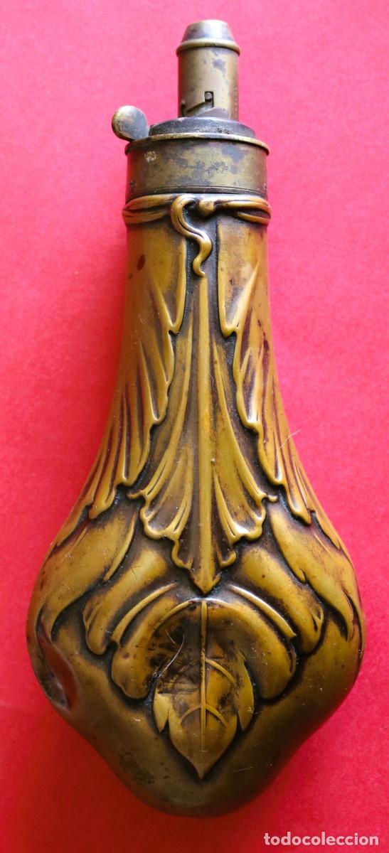 Militaria: Polvor&iacute;n con motivos vegetales, lat&oacute;n moldado, siglo XIX.