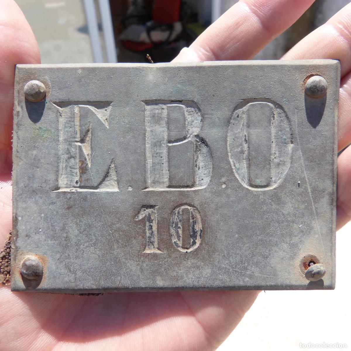 Militaria: Antigua placa de bronce con iniciales grabadas, E.B.O 10, posiblemente militar. 10x7cm, 47,30gr.