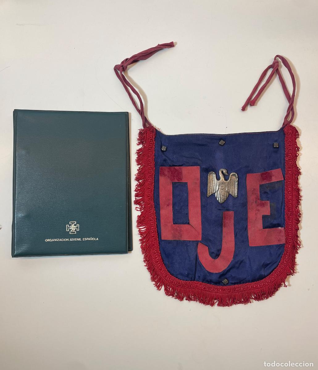 Militaria: OJE. Rar&iacute;simo Gui&oacute;n de Marcha Oficial Desmontable (22x22 cm) + Carpeta 1974