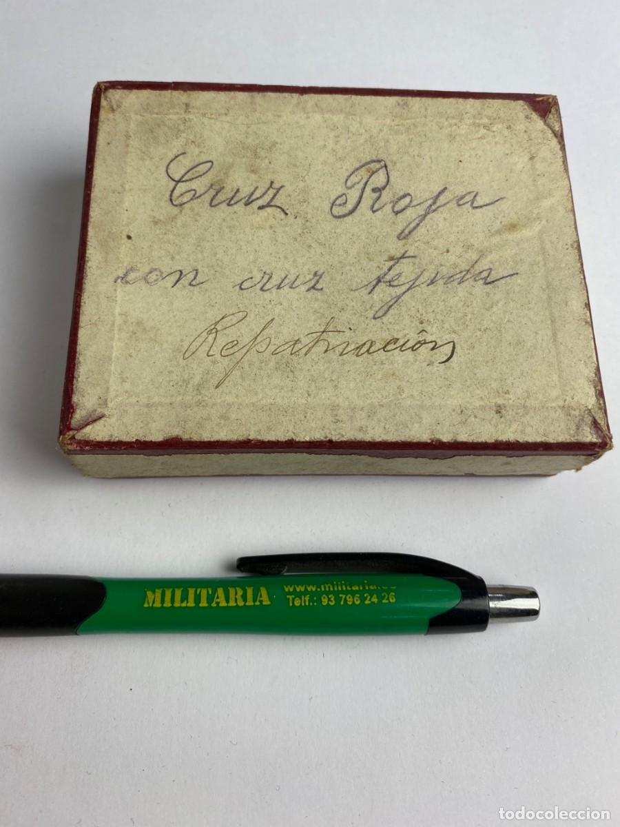 Militaria: Caja de Rosetas miniaturas de condecoraci&oacute;n para uso no uniformado con la inscripci&oacute;n CCRUZ ROJA CON