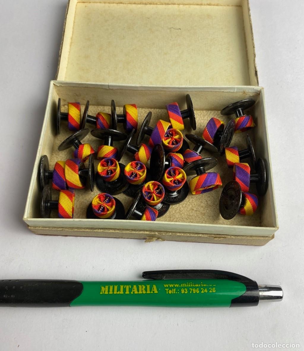 Militaria: Caja de Rosetas miniaturas de condecoraci&oacute;n para uso no uniformado con la inscripci&oacute;n GERONA 10