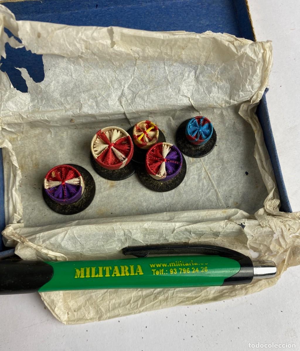 Militaria: Caja de Rosetas miniaturas de condecoraci&oacute;n para uso no uniformado con la inscripci&oacute;n MINDANAO M&Eacute;RIT