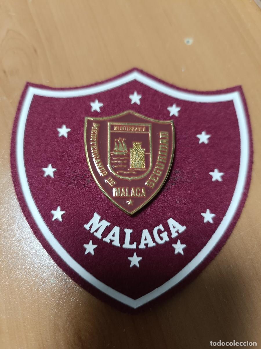 Militaria: ANTIGUO ESCUDO DE BRAZO DE EMPRESA DE SEGURIDAD DE MALAGA MEDITERR&Aacute;NEO, EN EL CENTRO ESCUDO MET&Aacute;LICO