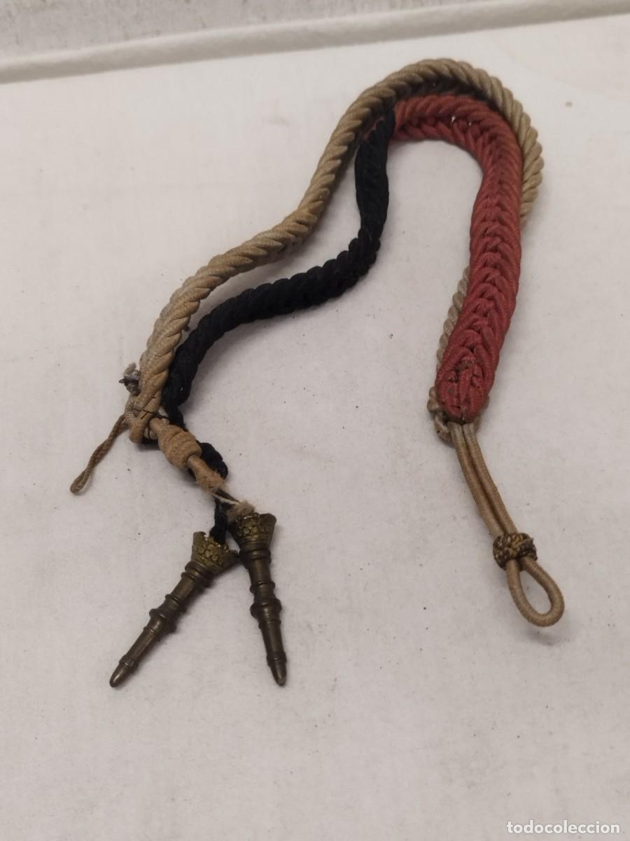 Militaria: Antiguo cord&oacute;n militar de cadete de academia. De color rojo, blanco y negro.