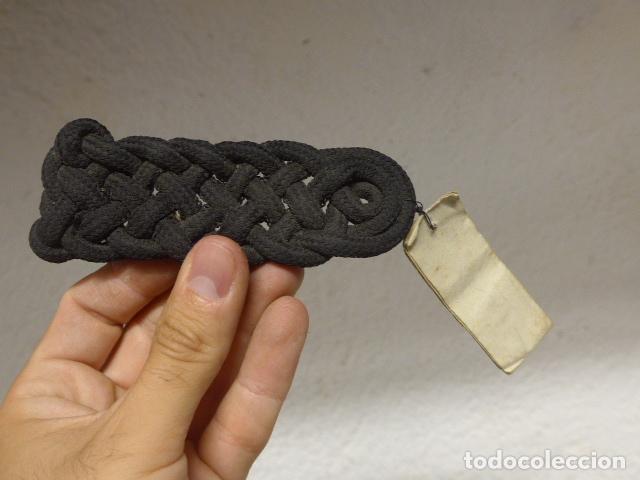 Militaria: Antigua hombrera militar espa&ntilde;ola en negro, con su etiqueta de origen.