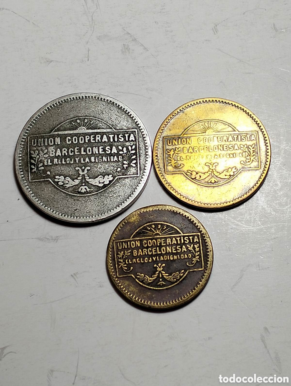 Monedas locales: Uni&oacute;n Cooperatistas Barcelonesa &rdquo;El reloj y la dignidad