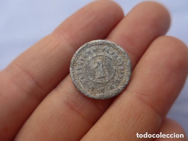 Monedas locales: Antigua moneda o ficha a identificar.
