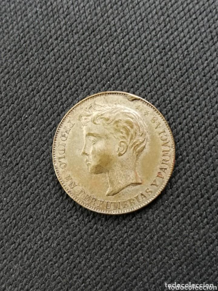 Monedas locales: FICHA PUBLICITARIA. ALFONSO XIII. FRICCIOL CURA LA CALVICIE, PEDIDLO EN PERFUMERIAS Y Farmacias.
