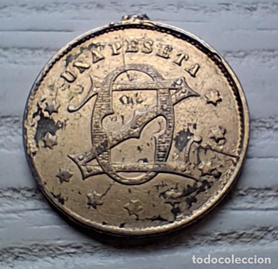 Monedas locales: Ficha antigua UNA PESETA con busto femenino y monograma, c. 1900-1930