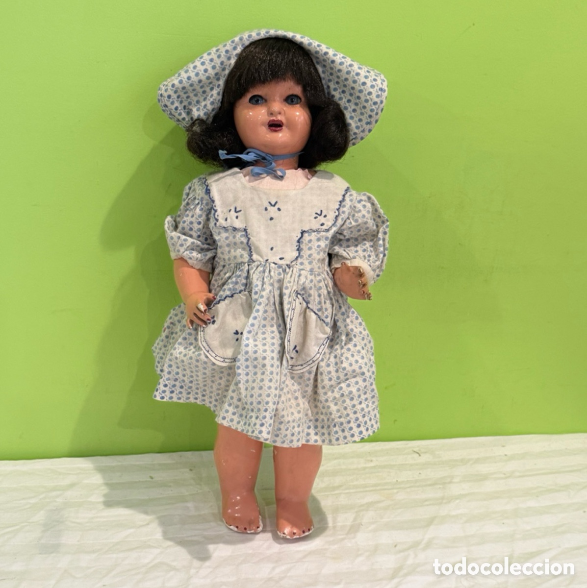 Mu&ntilde;eca espa&ntilde;ola clasica: Antigua mu&ntilde;eca de cart&oacute;n piedra &ndash; Pelo negro, ojos azules, vestido y capota &ndash; A&ntilde;os 40-50