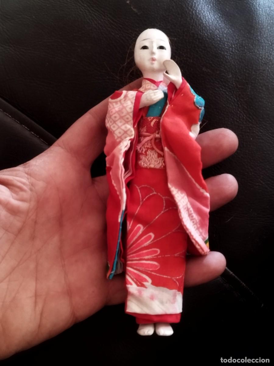 Mu&ntilde;ecas modernas: Antigua mu&ntilde;eca Geisha japonesa con un kimono rojo tradicional. Falta pelo, calva.