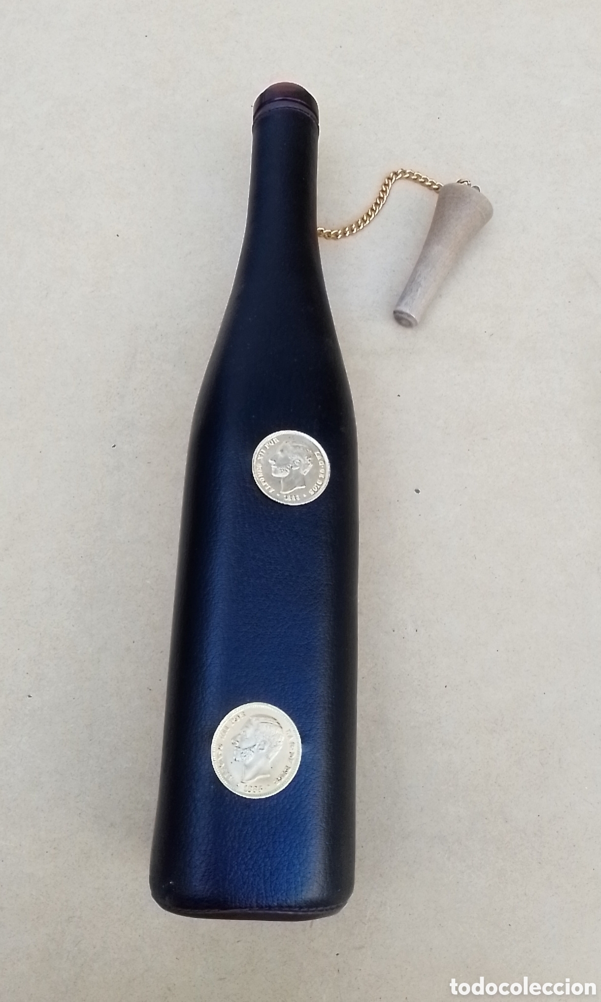 Otras botellas y bebidas antiguas de colecci&oacute;n: Botella cristal forrada de cuero con dos monedas Alfonso XII