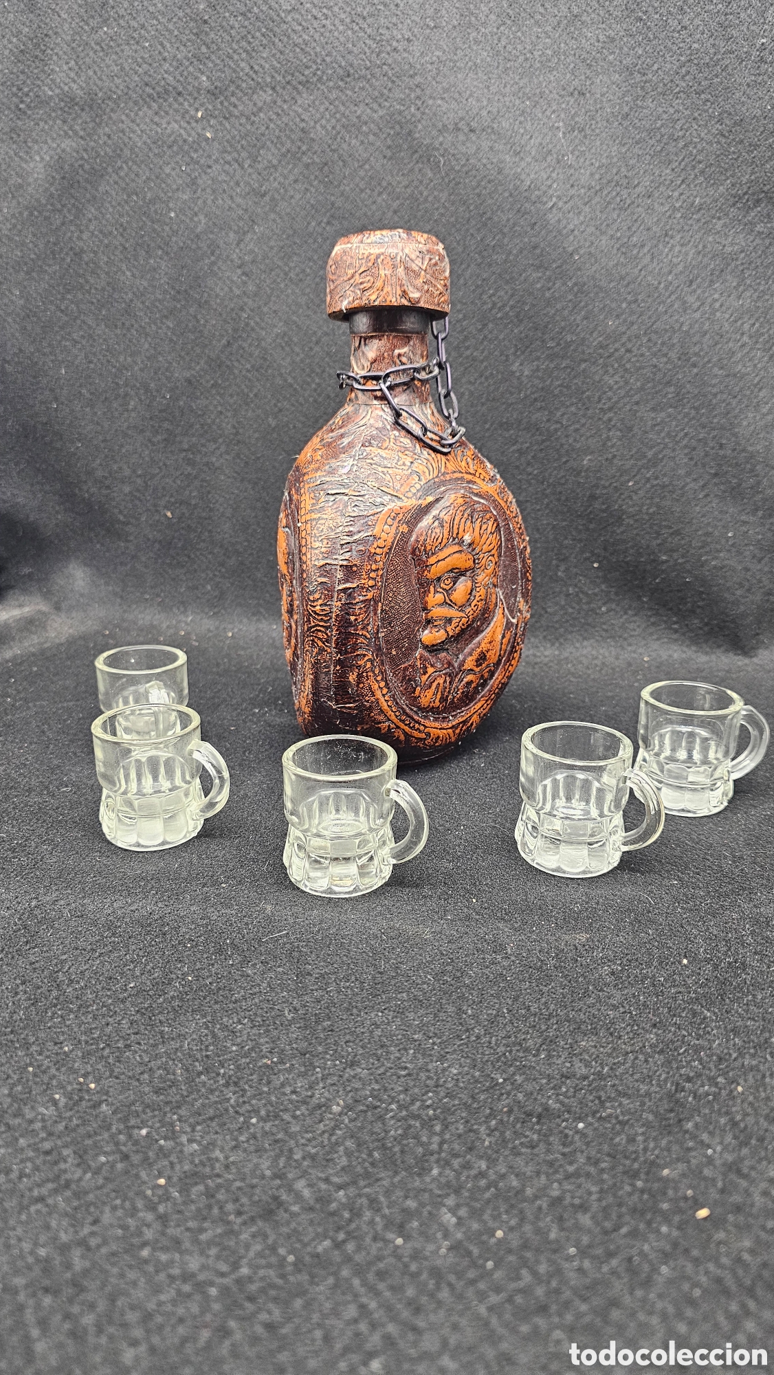Otras botellas y bebidas antiguas de colecci&oacute;n: Antigua licorera forrada de cuero repujado