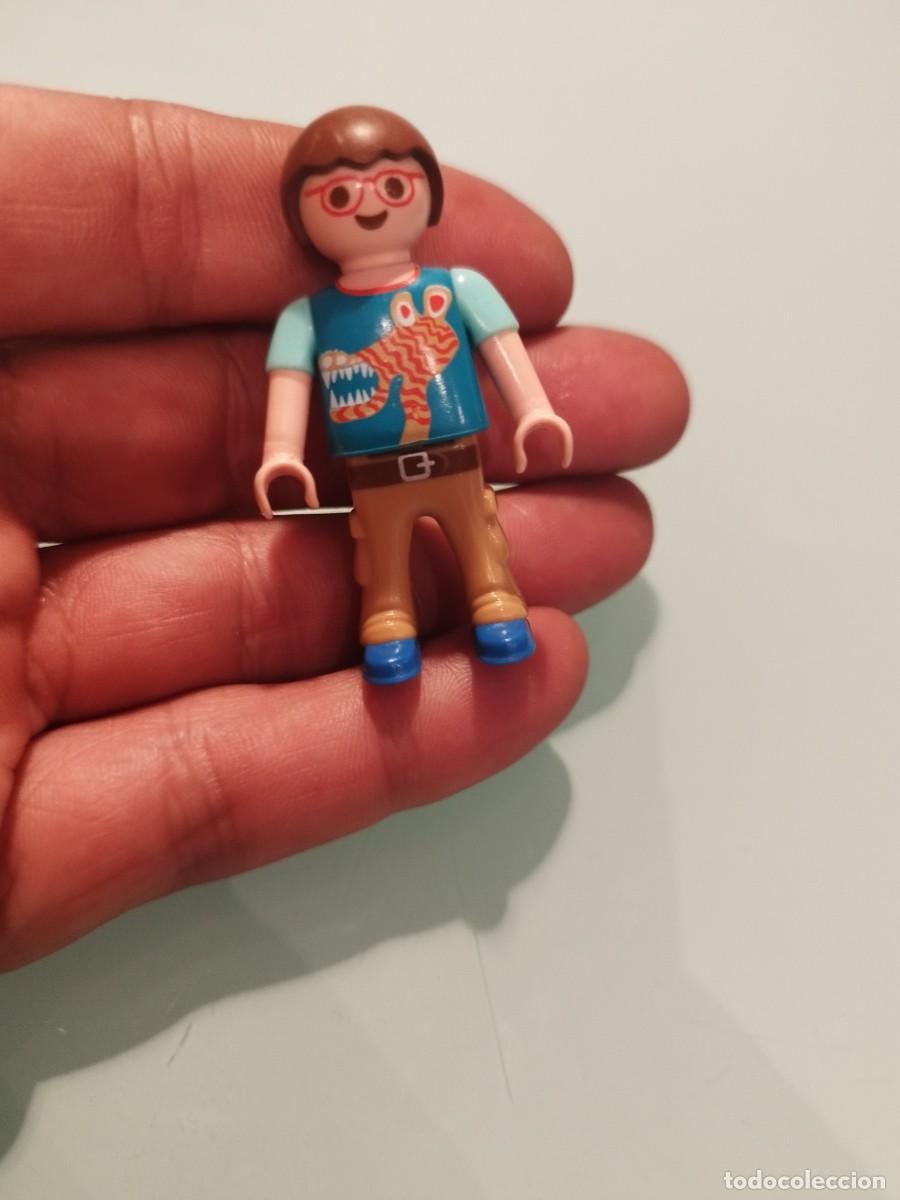 Playmobil: Figura de Playmobil de un ni&ntilde;o con gafas y pantalones de explorador. Camiseta con jirafa dinosaurio.