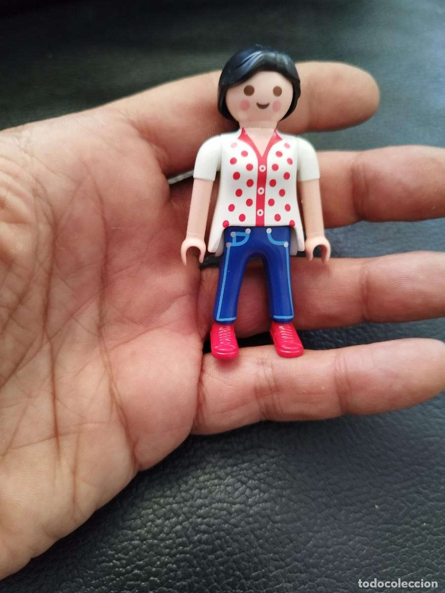 Playmobil: Figura Playmobil, chica morena con camisa blanca topos rojos y coleta.