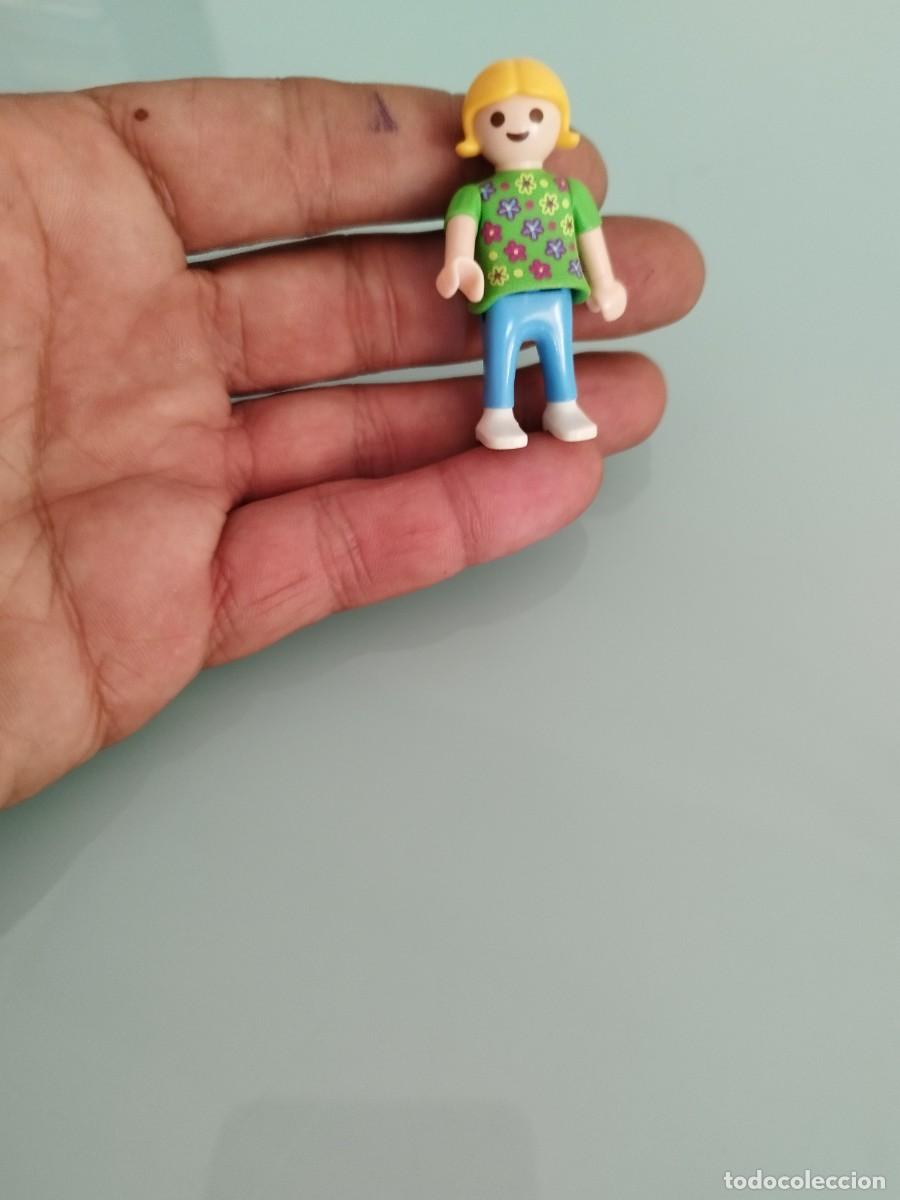 Playmobil: Figura playmobil, ni&ntilde;a con camiseta verde y flores de colores. Margaritas.