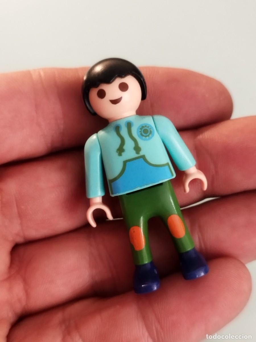 Playmobil: Figura Playmobil. Ni&ntilde;o con pelo negro, sudadera azul claro y pantalones verdes con detalles naranjas