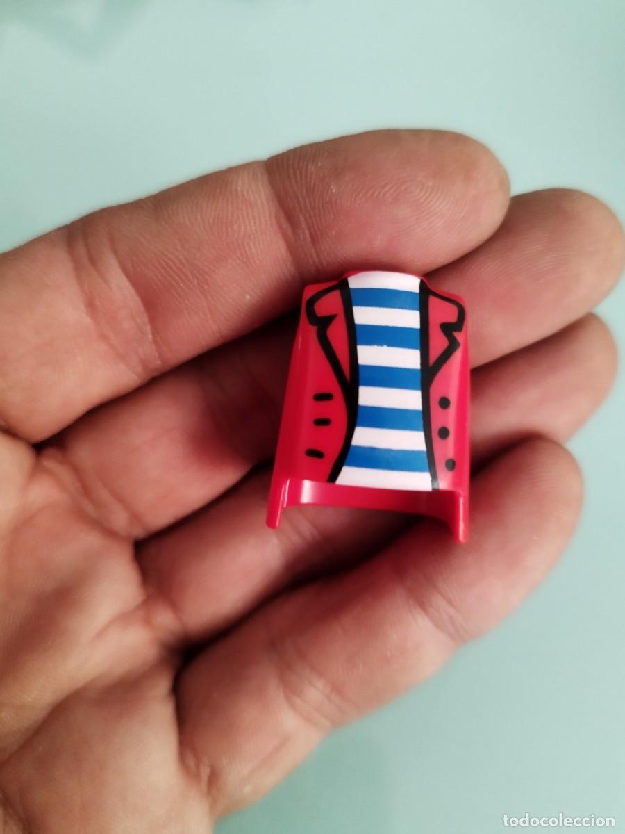 Playmobil: Figura Playmobil. chaqueta roja abierta sobre una camisa de rayas azules y blancas. Pirata, bucanero