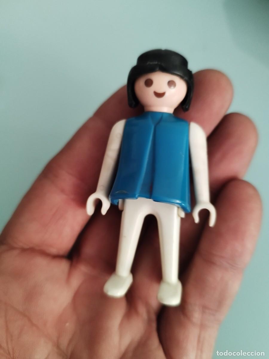 Playmobil: Figura Playmobil, geobra. Chica morena torso azul, piernas y brazos blancos.