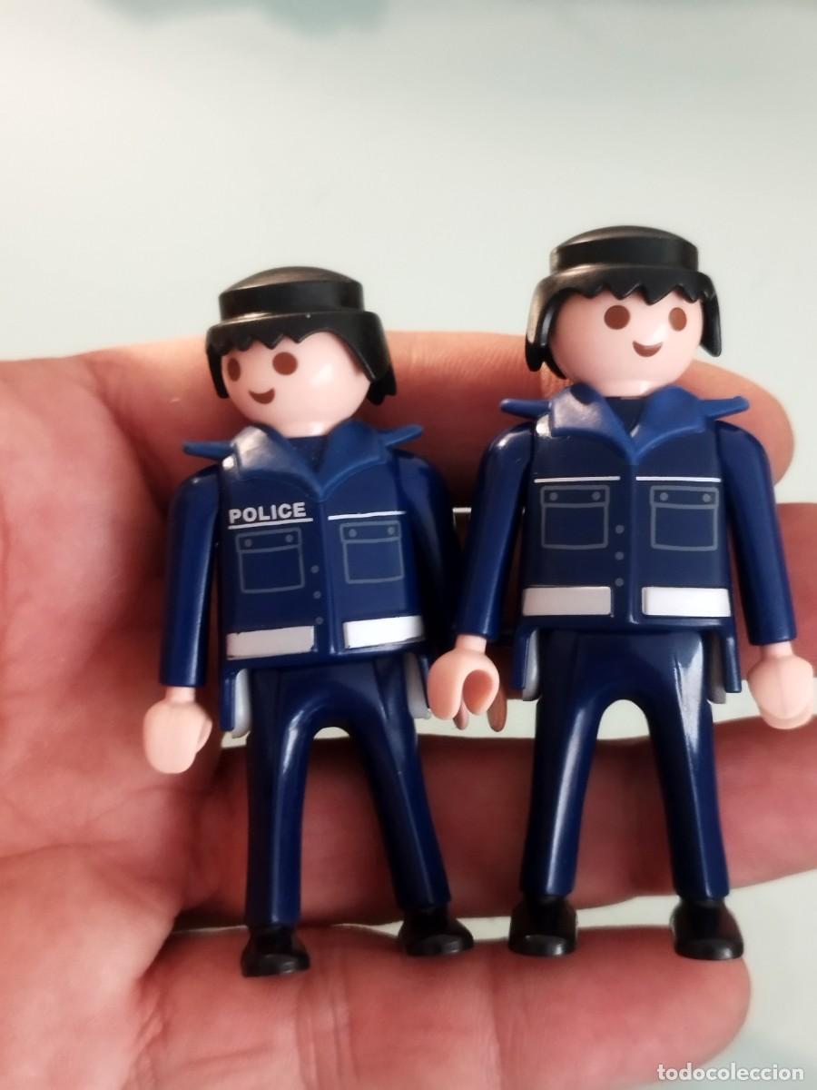 Playmobil: Figura Playmobil. Dos polic&iacute;as con uniforme azul oscuro, bandas reflectantes blancas.