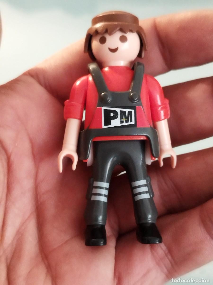 Playmobil: Figura Playmobil. Obrero, operario camisa roja, peto gris oscuro con las letras &rdquo;PM&rdquo; y pelo casta&ntilde;o.