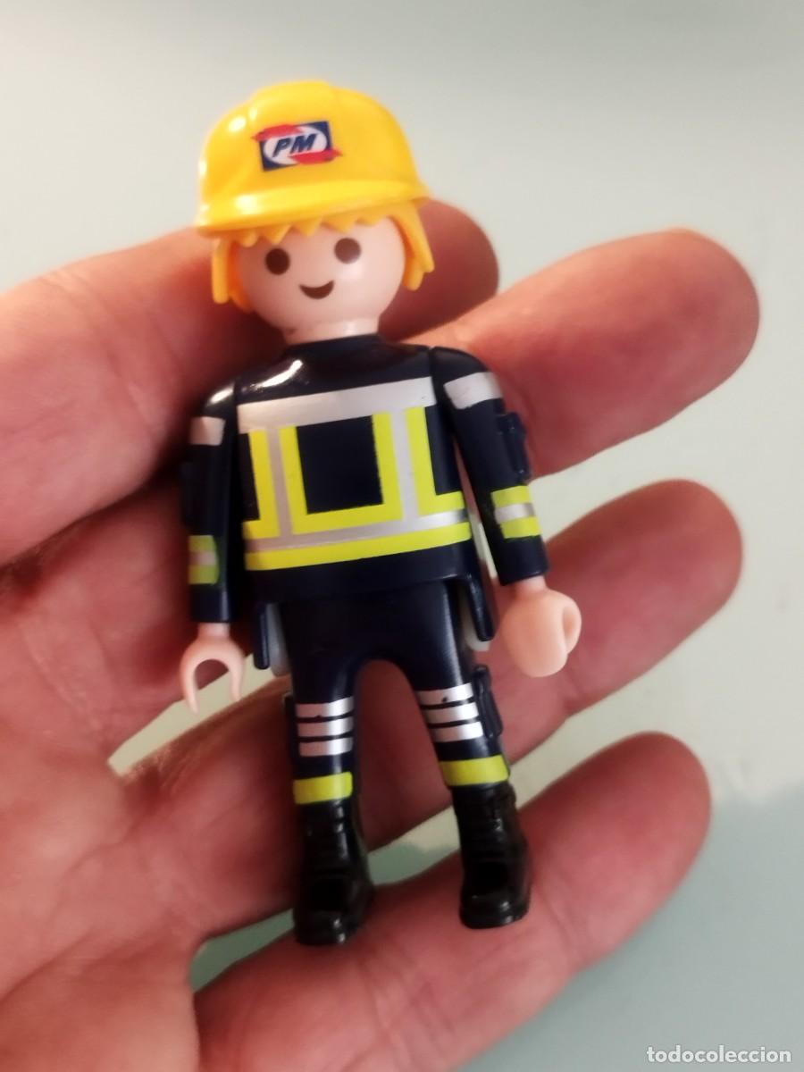Playmobil: Figura Playmobil. Bombero con casco amarillo con las letras PM.