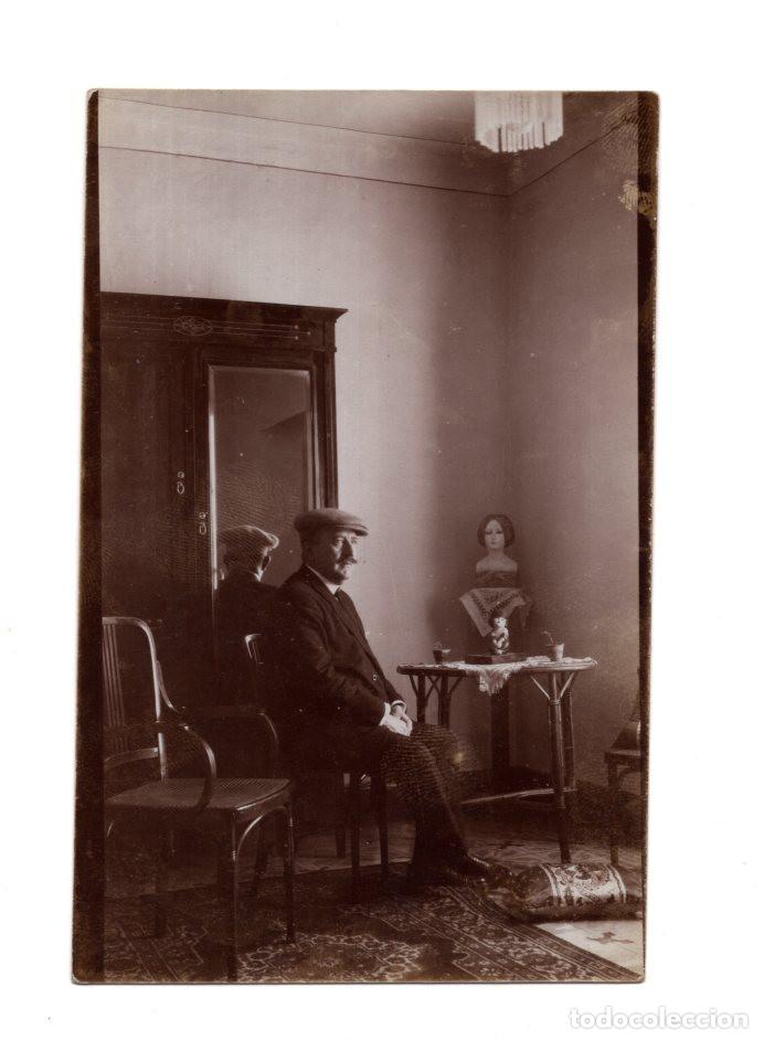 Postkarten: HOMBRE EN HABITACI&Oacute;N, MOBILIARIO CL&Aacute;SICO ARMARIO CON ESPEJO Y MESA CON UN BUSTO DECORATIVO ENCIMA.