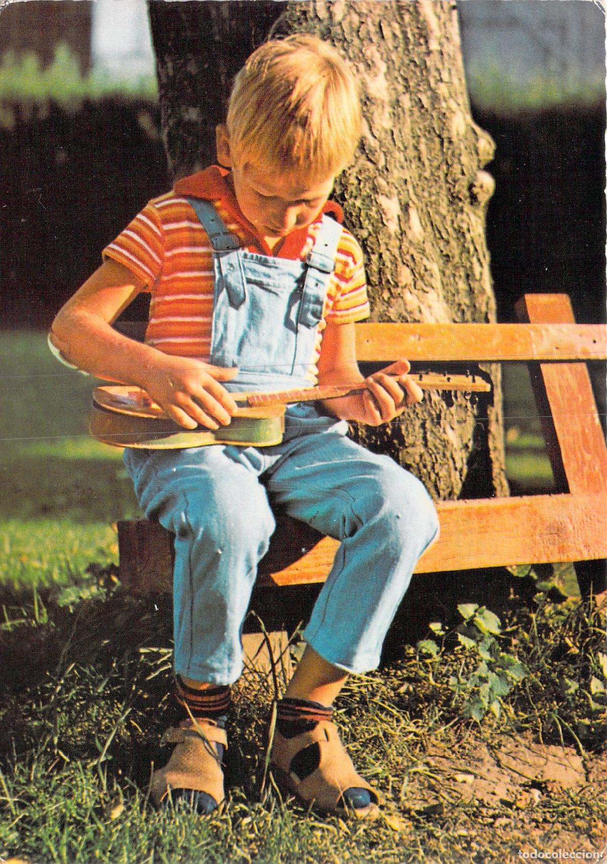 Postales: Postal de ni&ntilde;o tocando la guitarra sentado en un banco