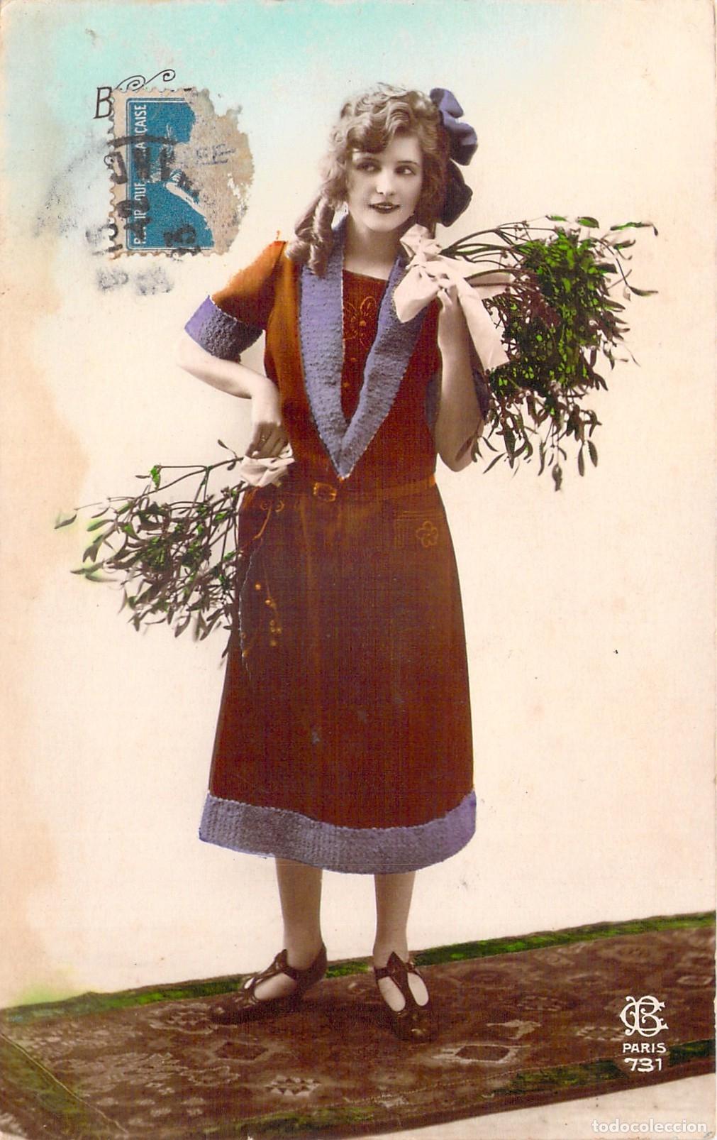 Postales: Postal de A&ntilde;o Nuevo con mujer sosteniendo mu&eacute;rdago