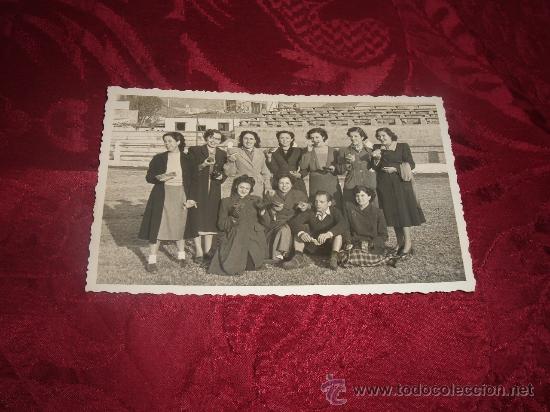 Collectionnisme sportif: grupo de mujeres con un jugador en el terreno de juego comiendo algun tipo de pasta