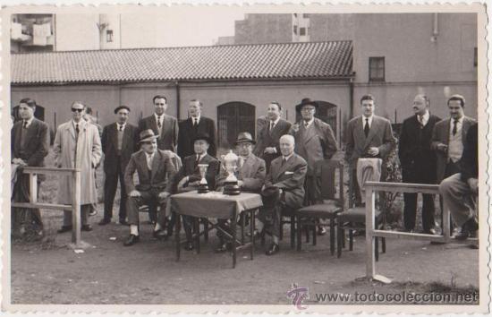 Collectionnisme sportif: Fotografia grupo de personajes delante los trofeos