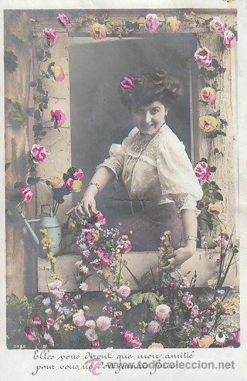 Cartoline: mujer cuidando las flores de su ventana