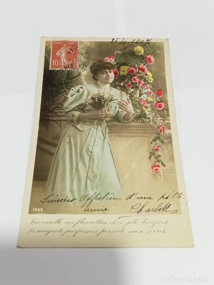 Postais: TARJETA POSTAL DE MUJERES. MUJER EN COLUMNA CUADRADA CON FLORES Y RAMILLETE EN SUS MANOS
