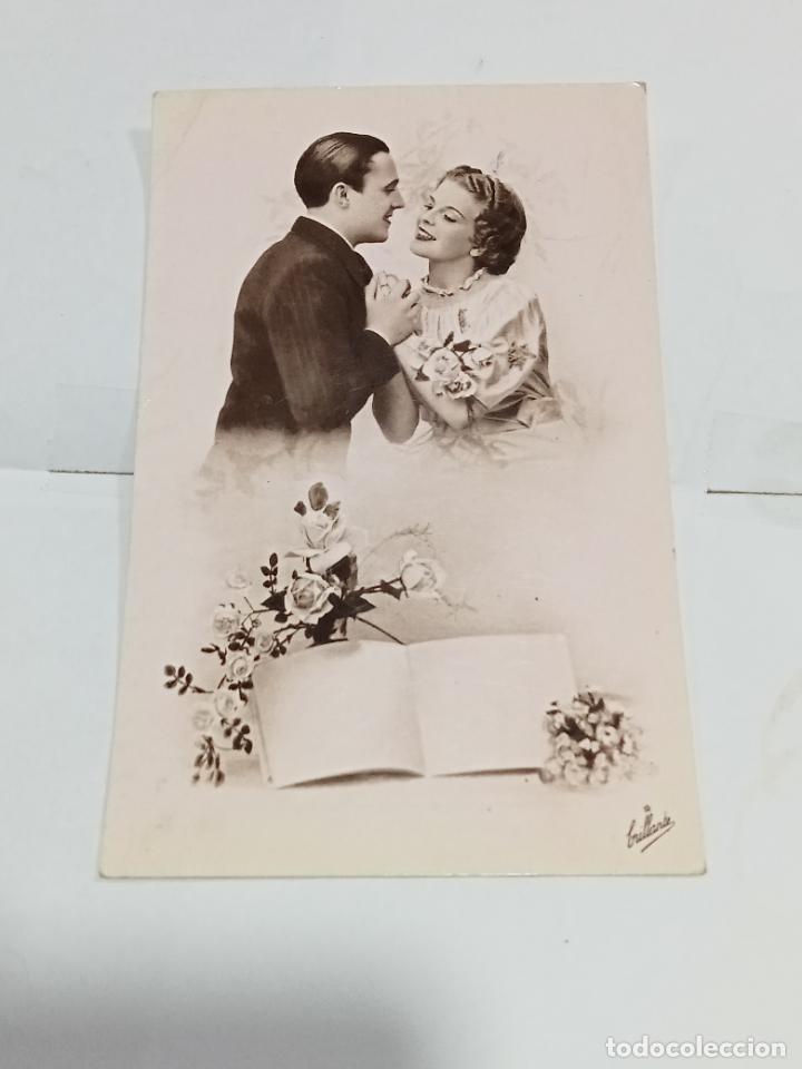 Cartoline: TARJETA POSTAL. PAREJA DE J&Oacute;VENES ENAMORADOS RODADO DE ROSAS CON LIBRO EN BLANCO POR ESCRIBIR