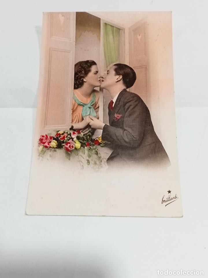 Cartoline: TARJETA POSTAL. PAREJA DE ENAMORADOS BES&Aacute;NDOSE EN LA VENTANA CON MACETA DE FLORES